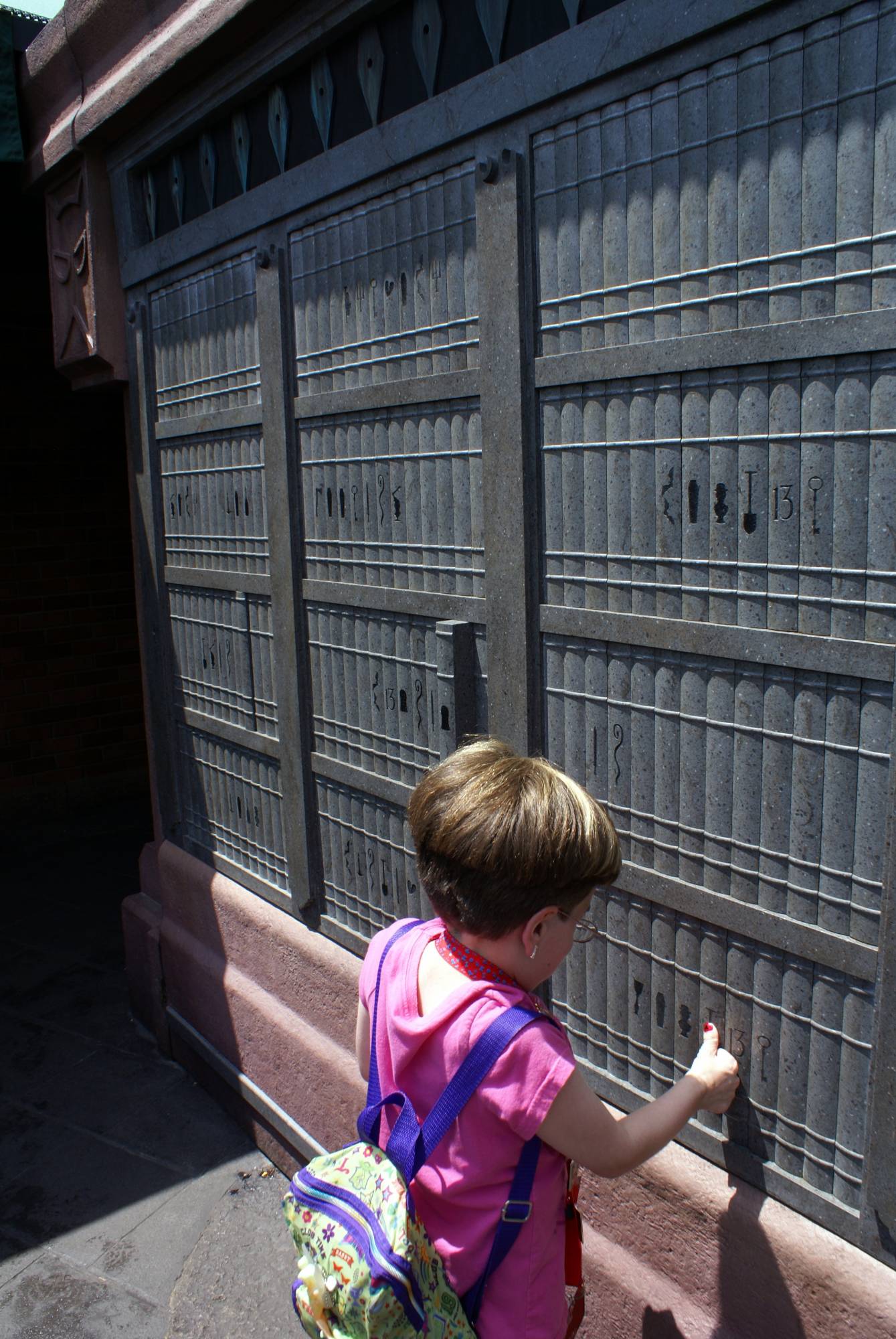 Stefanie playing with Bookshelves in Interactive Queue at Haunted Mansion